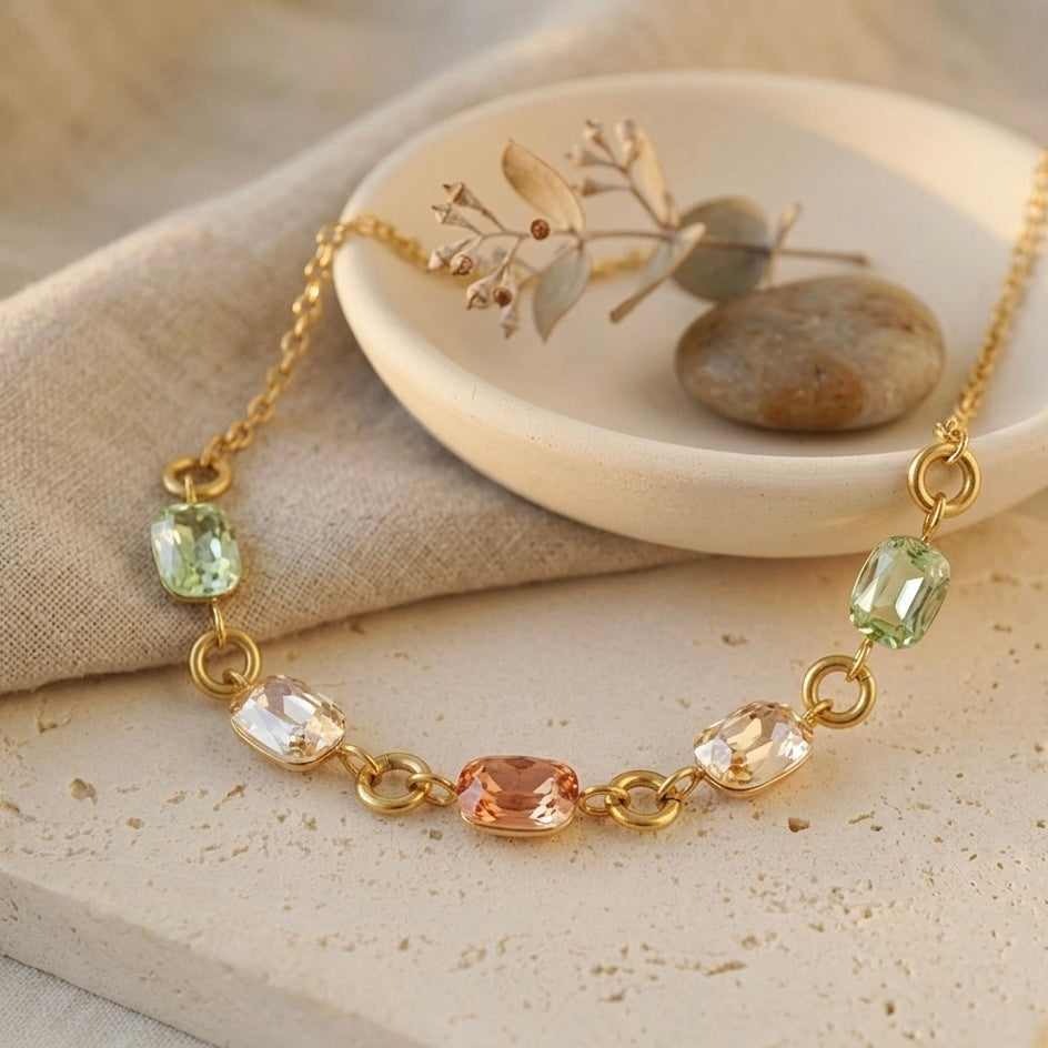 Aura Prism gold choker laid flat on a white stone surface.