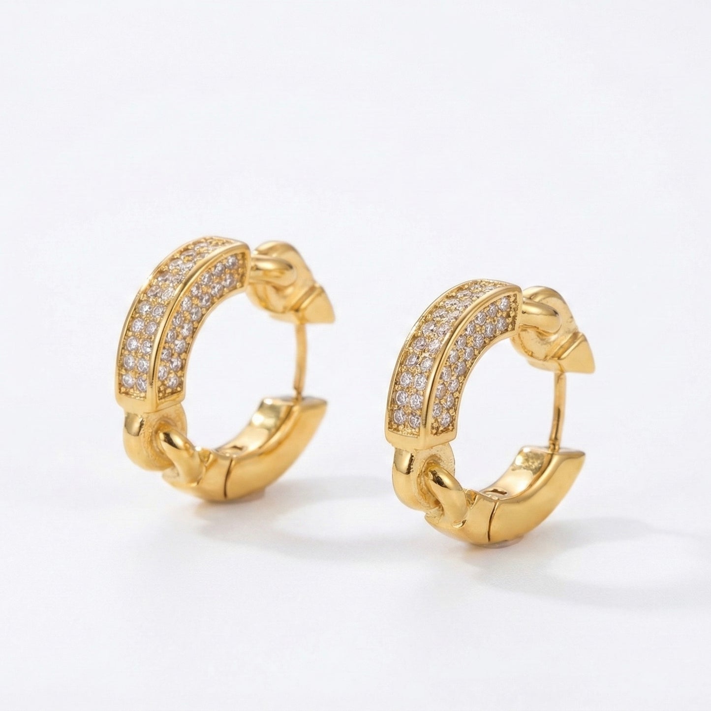 Gold hoop earrings with diamond accents on a white background