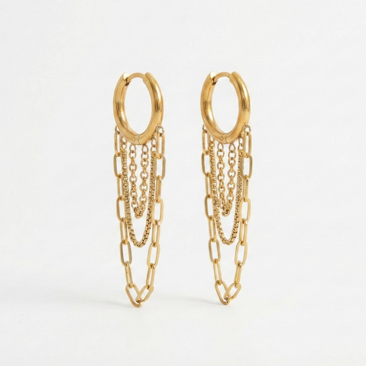 Gold huggie hoop earrings with three dangling chains in paperclip and box textures. 18k gold plated anti-tarnish jewelry by Glow Petal.