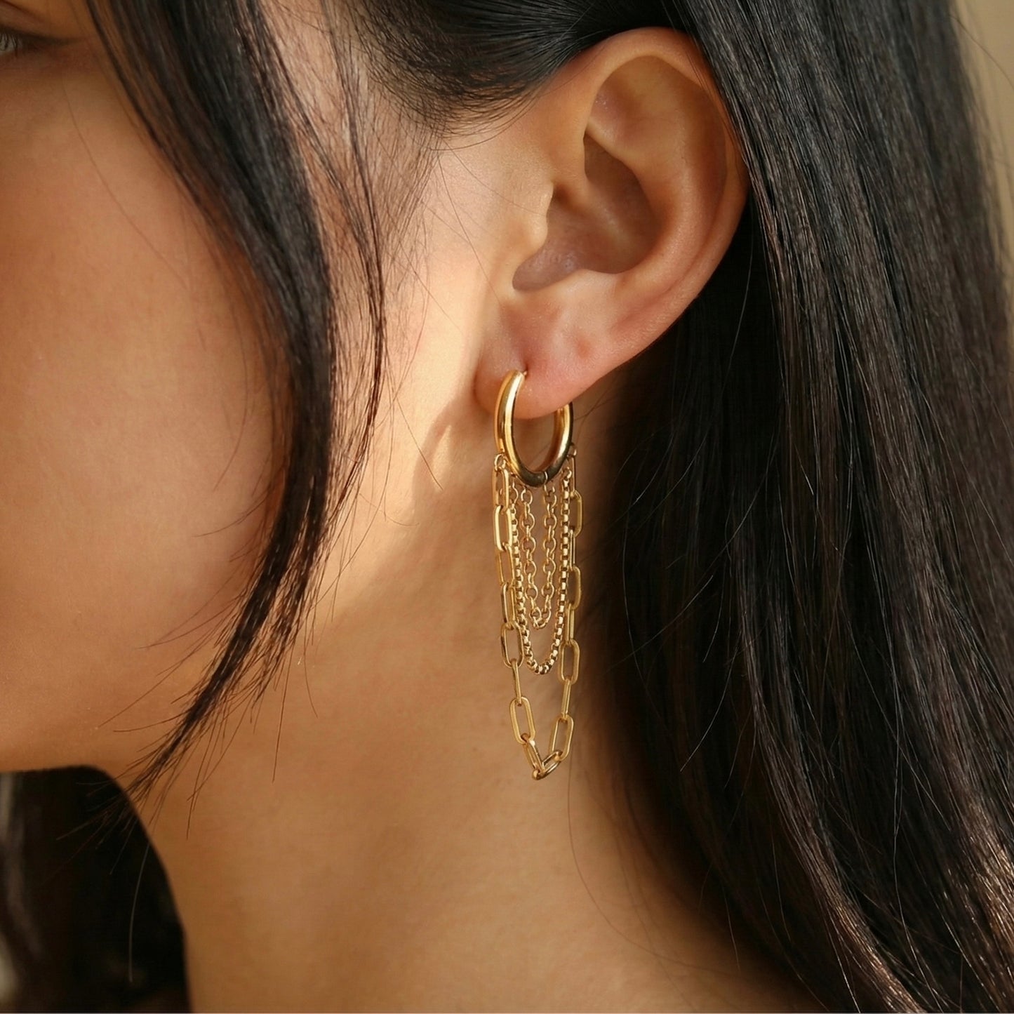 Close up detail of triple chain drop earrings showing paperclip and cable chain textures. High-quality gold vermeil style hoops.