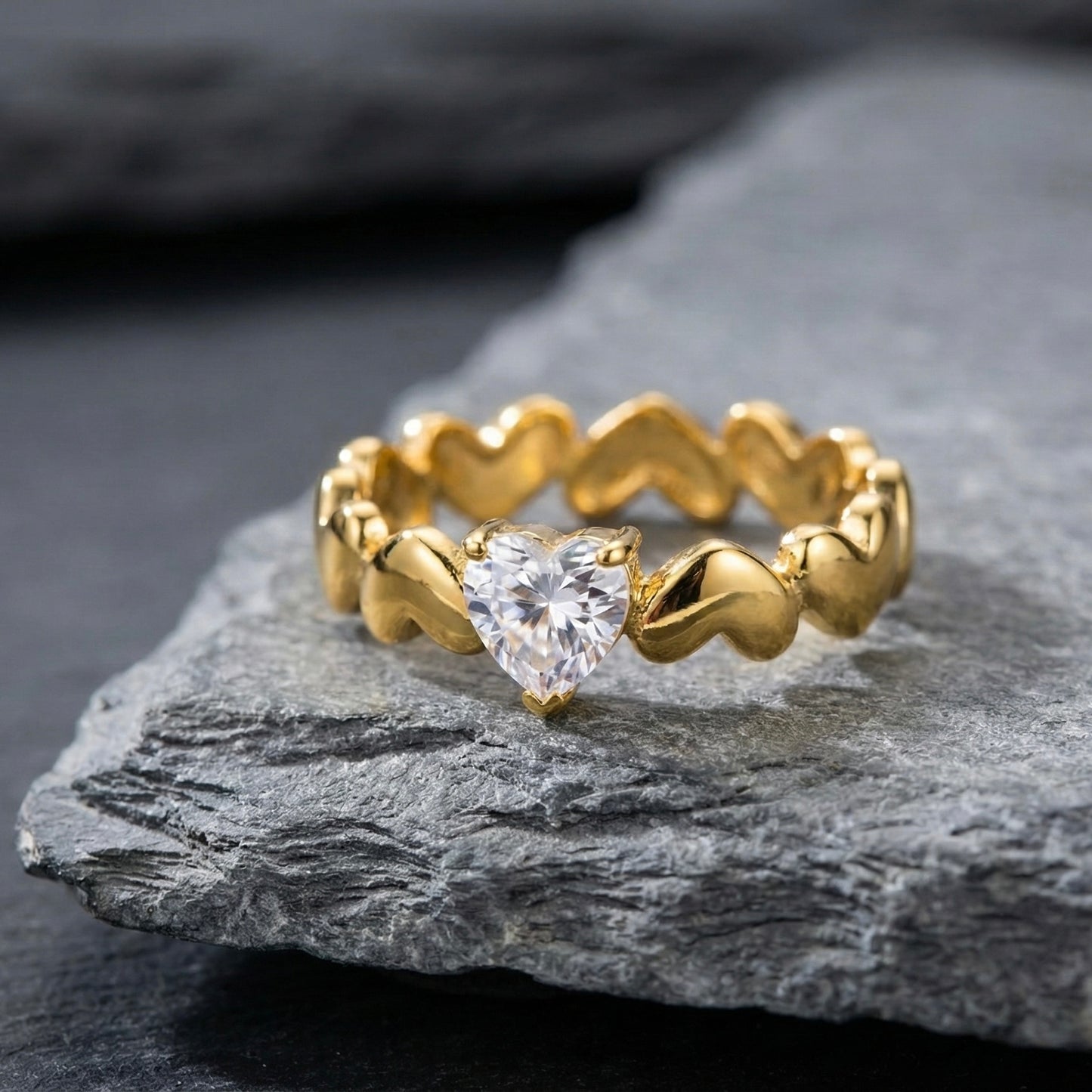 Close up of gold heart-link band ring with cubic zirconia stone.