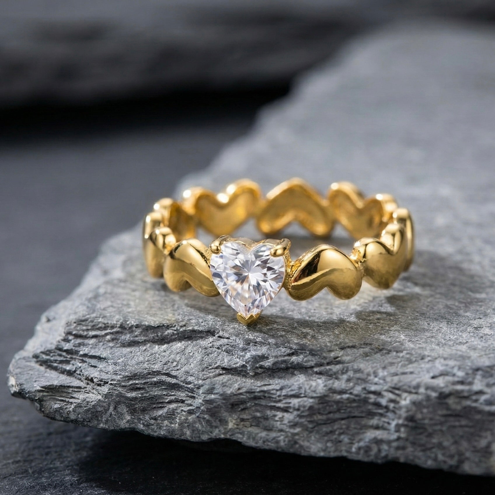 Close up of gold heart-link band ring with cubic zirconia stone.