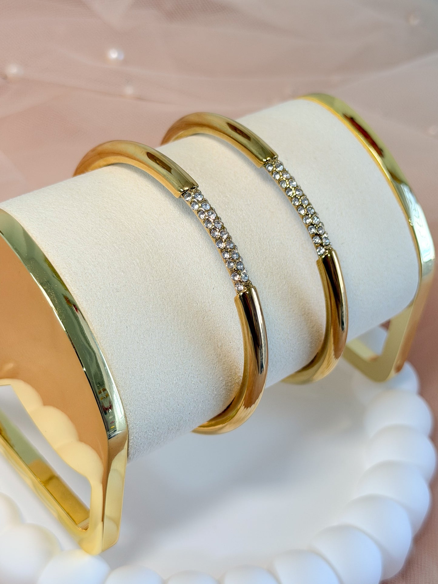 Close up of 18K gold plated open cuff bangle with pave crystal bar accent. Waterproof stainless steel jewelry on white display