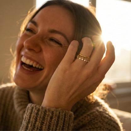 Women wearing Waterproof gold shaker ring with moving cubic zirconia stones.