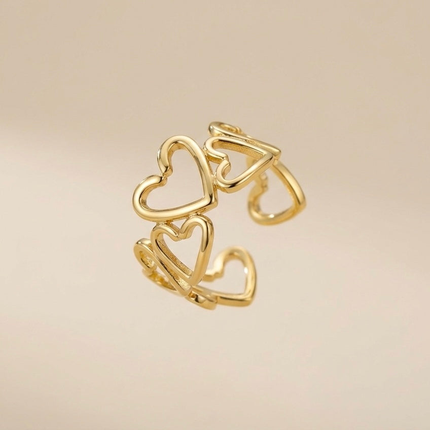 Gold heart-shaped ring on a beige background