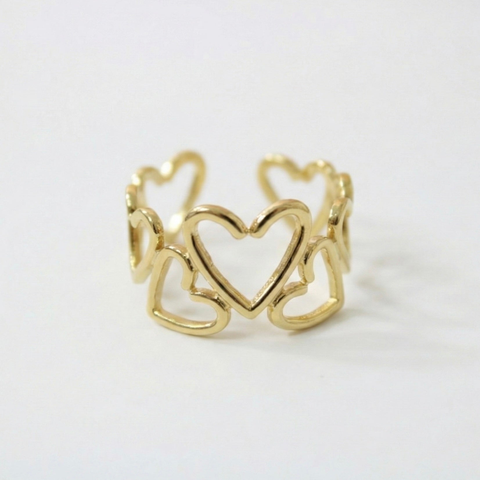 Gold ring with heart design on a white background