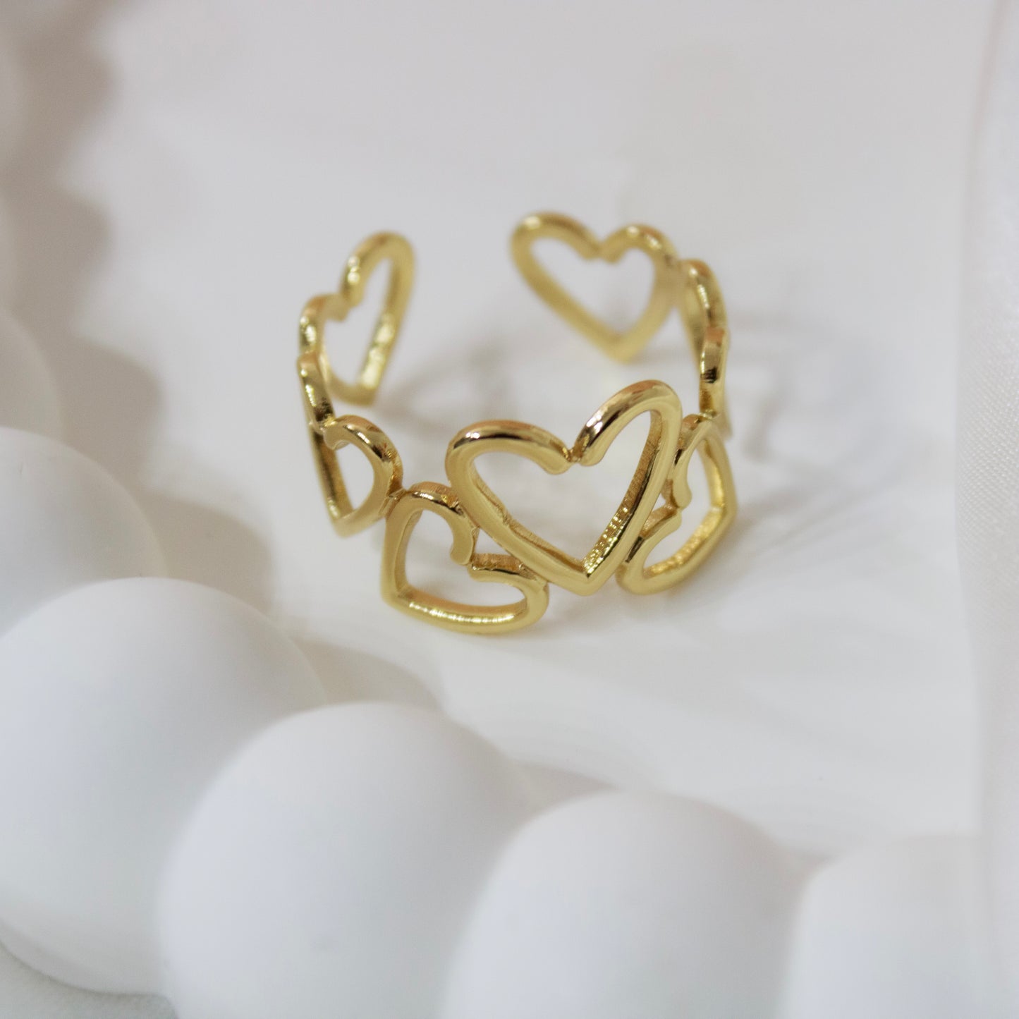 Gold heart-shaped ring on a white background