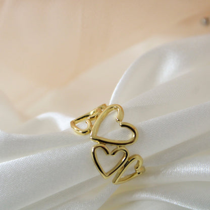 Gold heart-shaped ring on a white fabric background