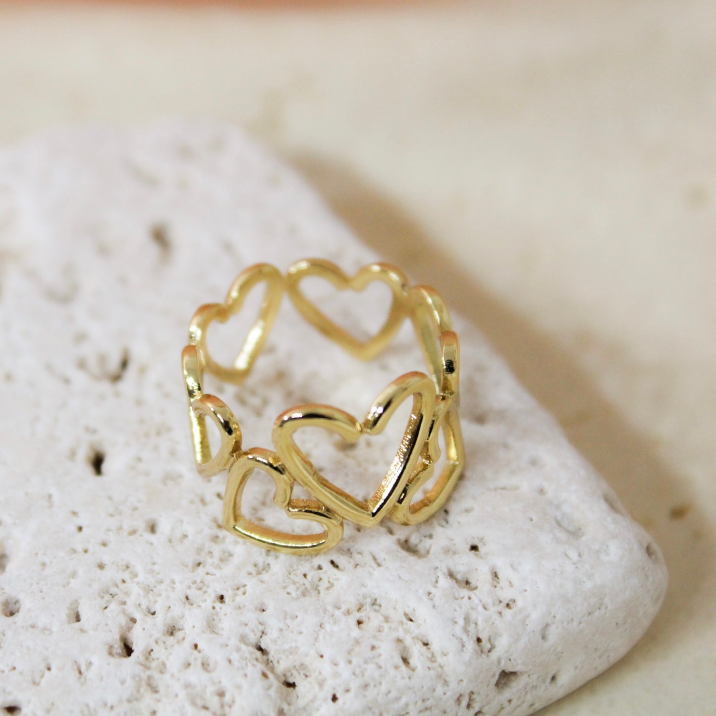 Gold heart-shaped ring on a textured stone surface